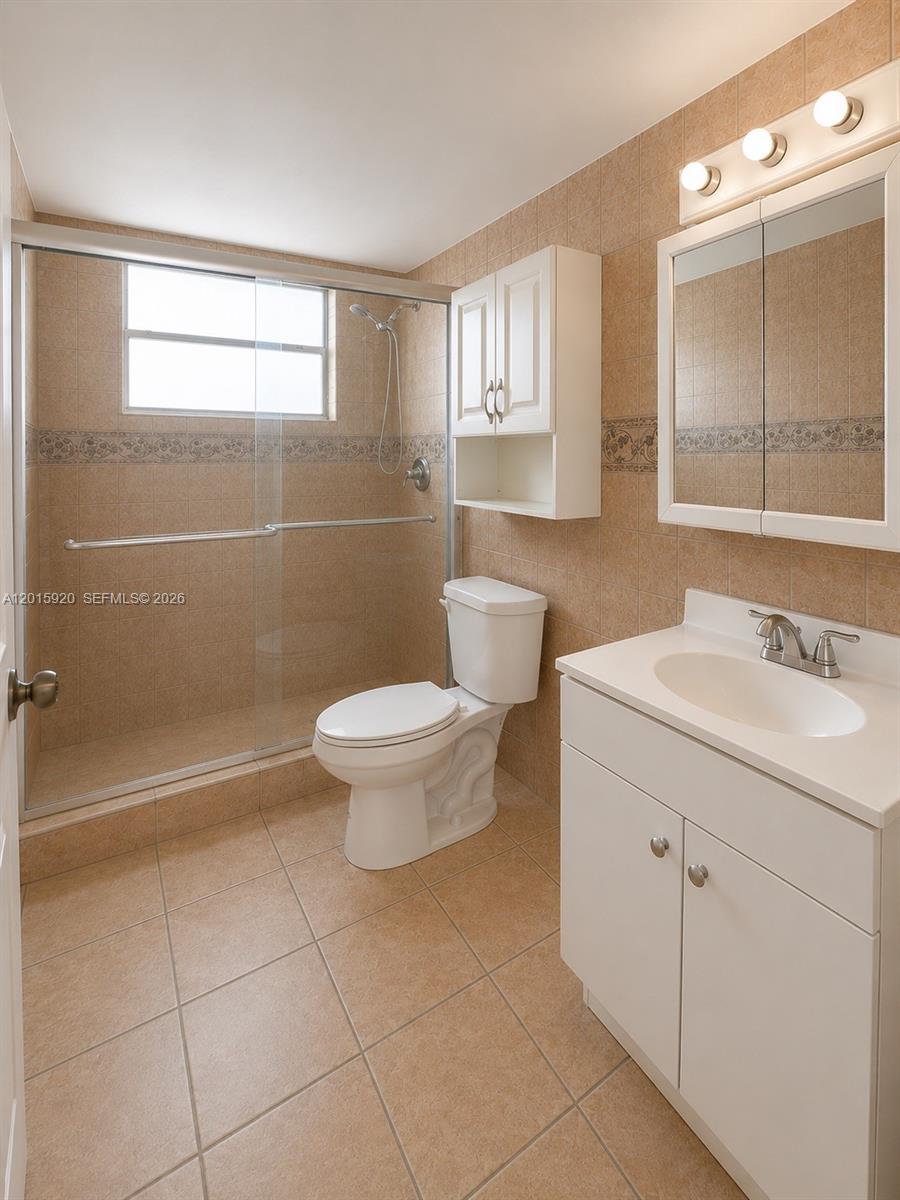 14170 Southwest 84th Street, Unit 404F Miami, FL 33183 - Photo 7 of 18 a bathroom with a sink a toilet and shower