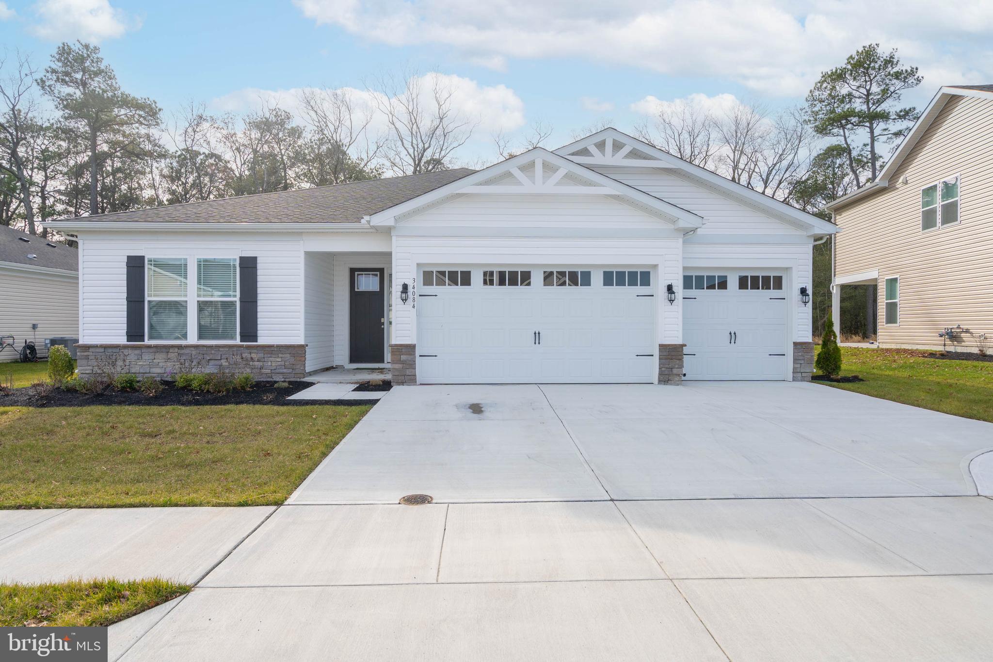 a view of a white house with a yard and potted plants