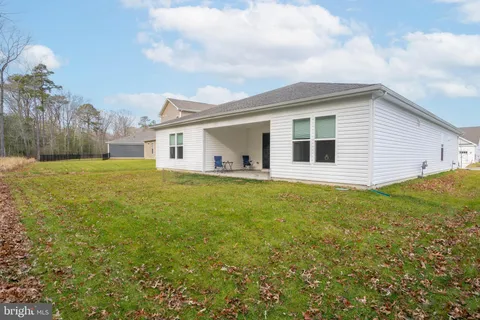 a view of a house with a backyard and a chair