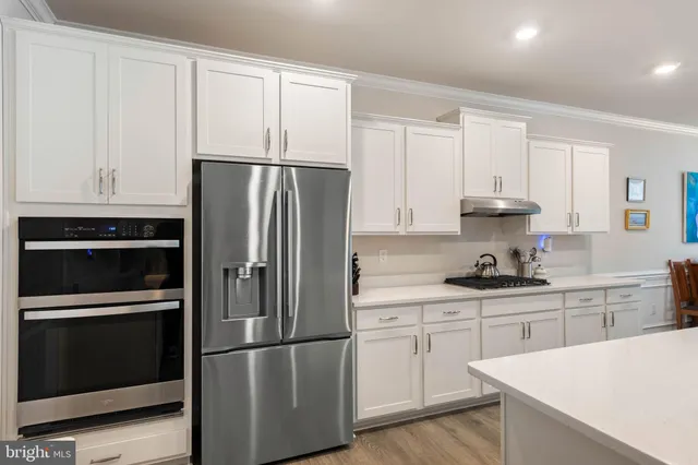 a kitchen with white cabinets and stainless steel appliances