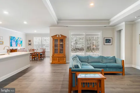 a kitchen with stainless steel appliances a refrigerator a stove top oven and a dining table with wooden floor