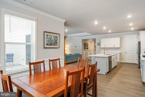 a large dining hall with stainless steel appliances granite countertop a stove kitchen island a table and chairs