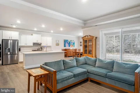 a view of a kitchen with kitchen island a sink stainless steel appliances and cabinets