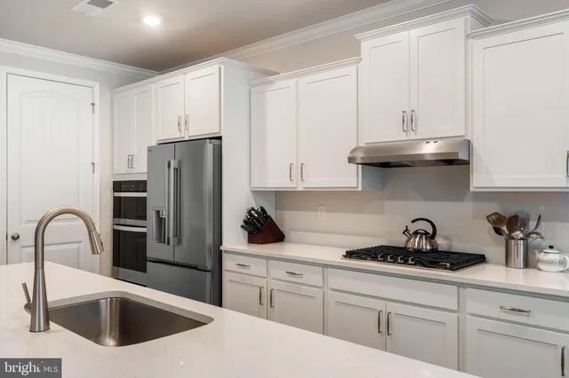 a kitchen with stainless steel appliances granite countertop a sink stove and cabinets