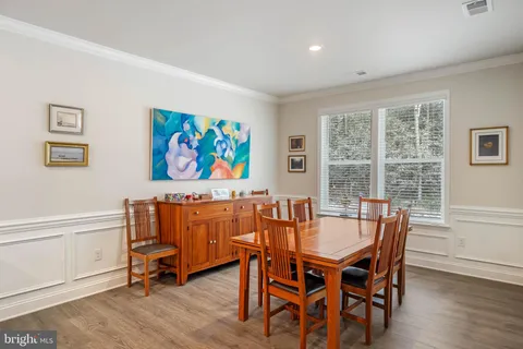 a large dining hall with stainless steel appliances granite countertop a stove kitchen island a table and chairs