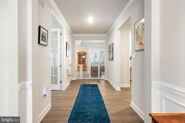 a view of a hallway with wooden floor and windows
