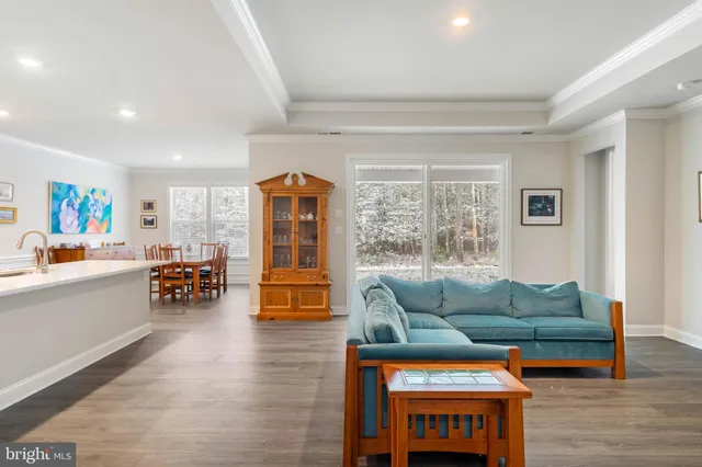 a living room with furniture and a dining table with wooden floor
