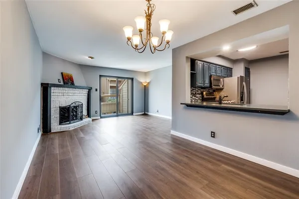 a view of a livingroom with wooden floor and a fireplace