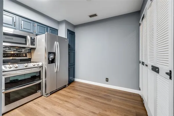 a view of a kitchen with a stove fridge and wooden floor
