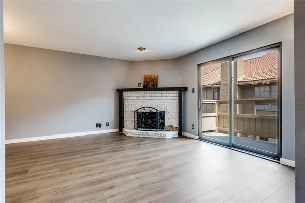 a view of an empty room with a fireplace and a window