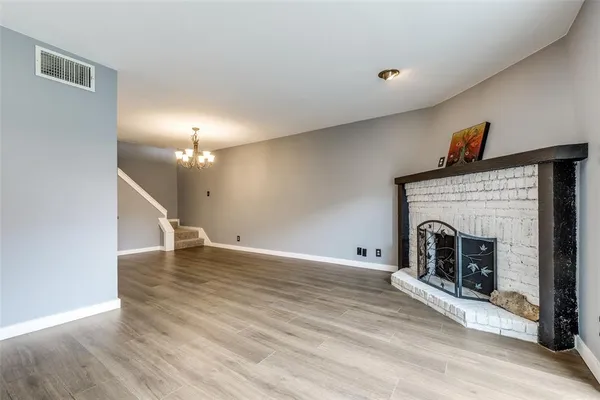 a view of a livingroom with wooden floor and a fireplace