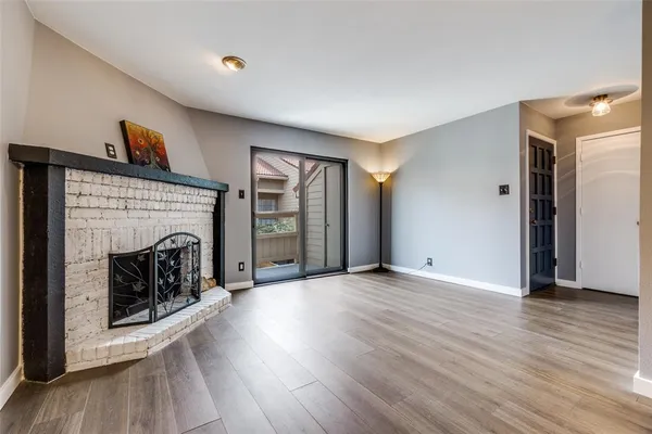 a view of a livingroom with wooden floor and a fireplace