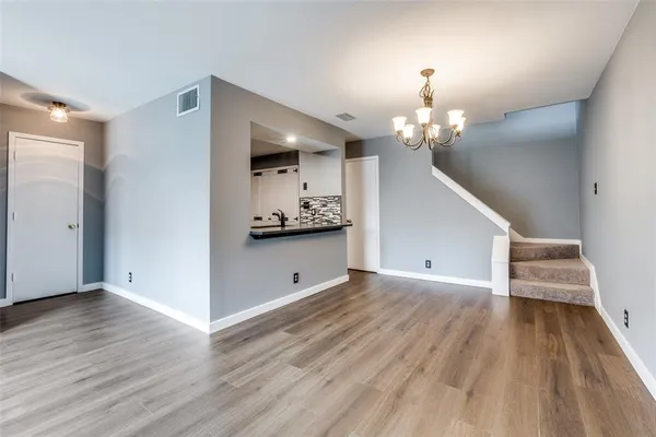 wooden floor in an empty room with a chandelier