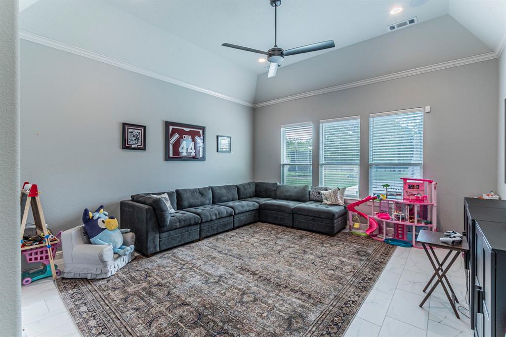 150 Las Brisas Drive Decatur, TX 76234 - Photo 22 of 32 Living room featuring ceiling fan, vaulted ceiling, light marble finish flooring, recessed lighting, and ornamental molding