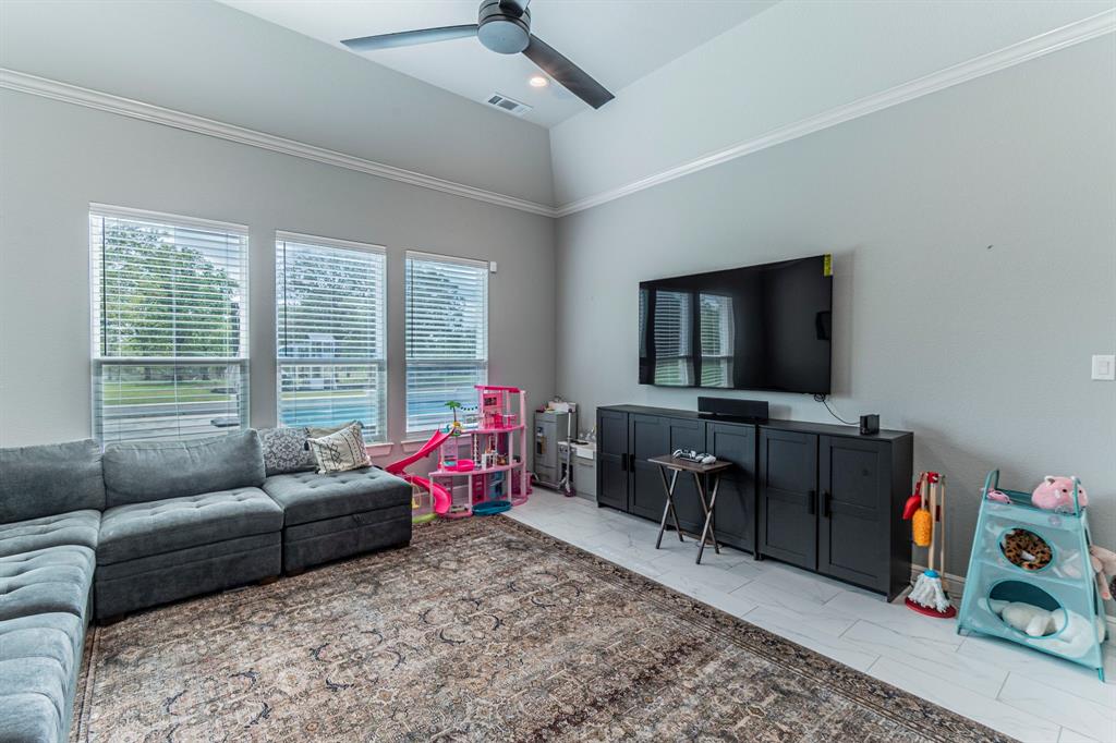 150 Las Brisas Drive Decatur, TX 76234 - Photo 23 of 32 Living room featuring a ceiling fan, lofted ceiling, crown molding, light marble finish flooring, and recessed lighting