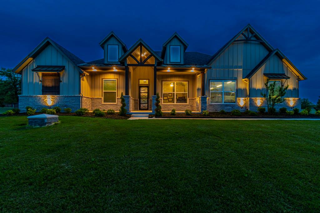 150 Las Brisas Drive Decatur, TX 76234 - Photo 3 of 32 Craftsman-style home with covered porch, board and batten siding, stone siding, and a lawn