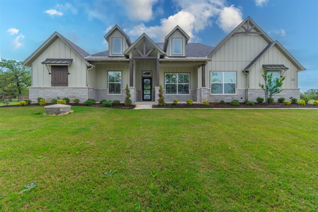150 Las Brisas Drive Decatur, TX 76234 - Photo 29 of 32 Craftsman-style house with board and batten siding, a porch, a front yard, and stone siding