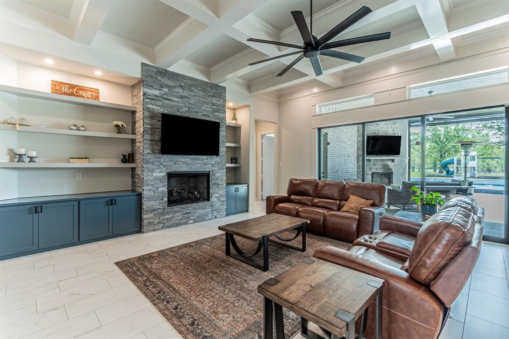 150 Las Brisas Drive Decatur, TX 76234 - Photo 5 of 32 Living area with a fireplace, ceiling fan, built in features, coffered ceiling, and light marble finish floors