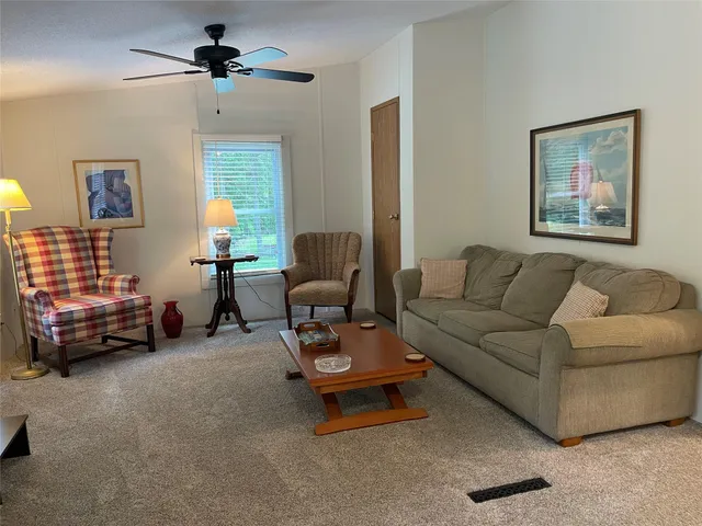 a living room with furniture and a ceiling fan