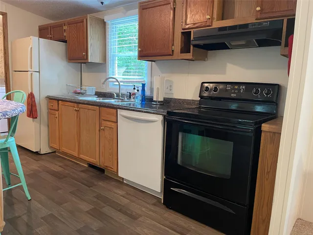 a kitchen with stainless steel appliances granite countertop a stove top oven a refrigerator a sink and a stove