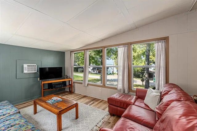 a living room with furniture a flat screen tv and a floor to ceiling window