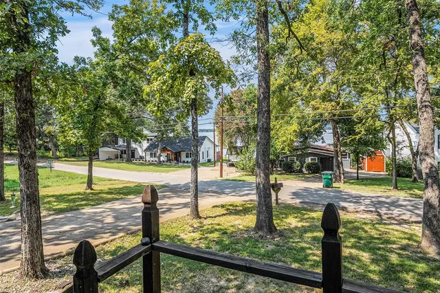 a view of a street with large trees