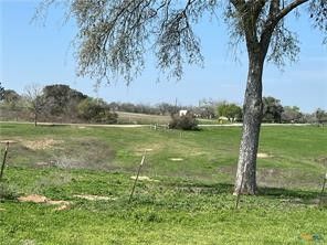 a view of a lake with a big yard and large trees