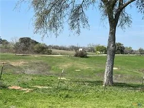 a view of a lake with a big yard and large trees