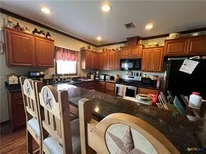 a kitchen with granite countertop a stove a sink and a refrigerator