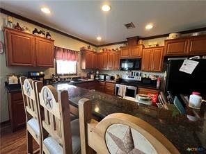 a kitchen with granite countertop a stove a sink and a refrigerator