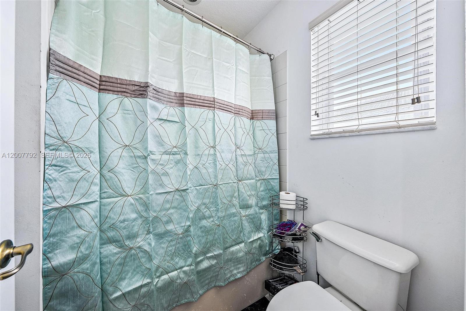 3229 Laurel Ridge Circle, Unit 3229 Riviera Beach, FL 33404 - Photo 11 of 24 a bathroom with a toilet and a shower curtain