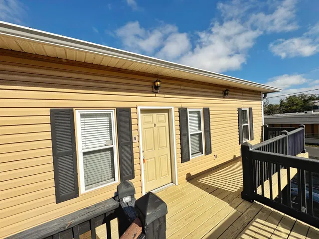 a front view of a house with barbeque oven and furniture