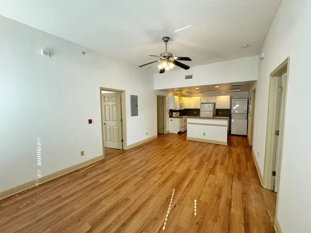 a view of a room with wooden floor and ceiling fan