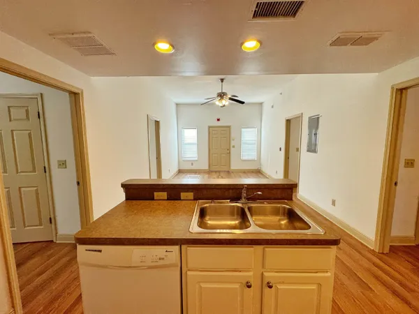 a view of a kitchen with a sink and refrigerator