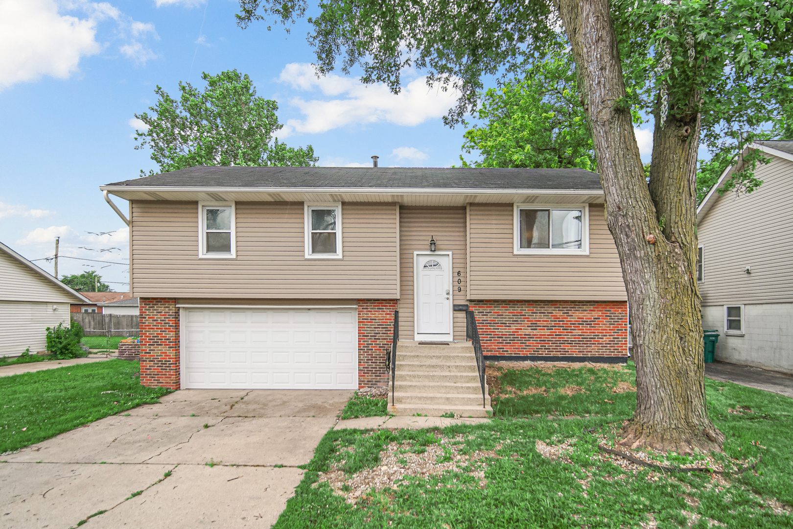 609 West Romeo Road Romeoville, IL 60446 - Photo 1 of 23 a front view of a house with a yard