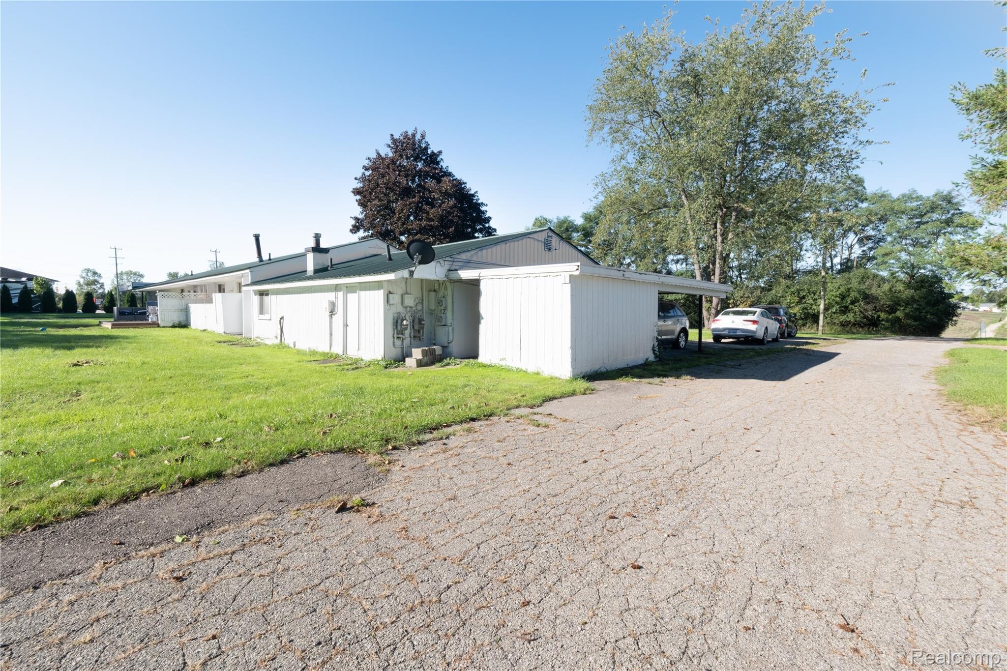 7038 Whitmore Lake Road Whitmore Lake, MI 48189 - Photo 32 of 32 Property exterior with a white facade, dark roof, and a paved driveway