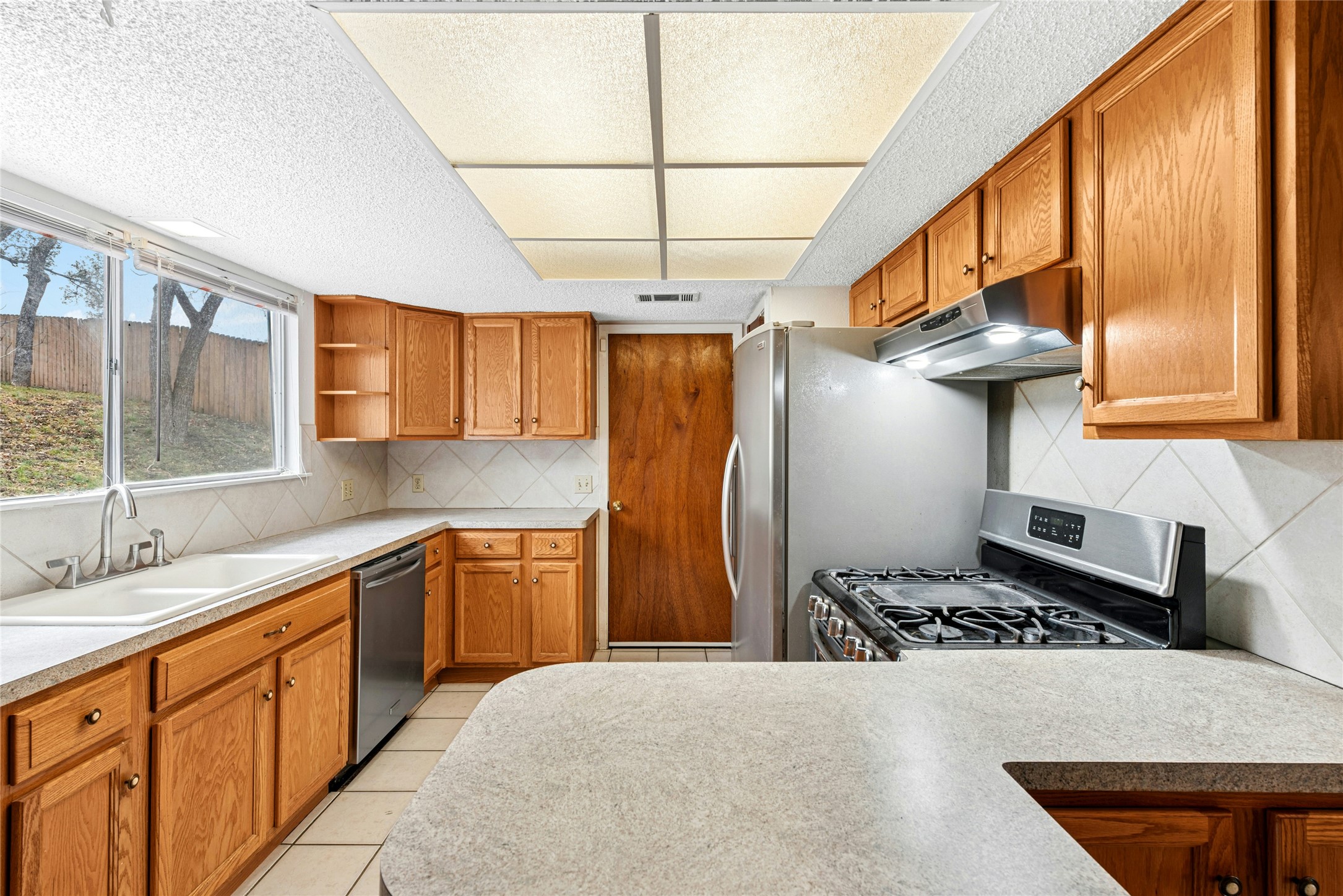 1444 Salem Meadow Circle Austin, TX 78745 - Photo 11 of 35 a kitchen with stainless steel appliances a sink window and cabinets