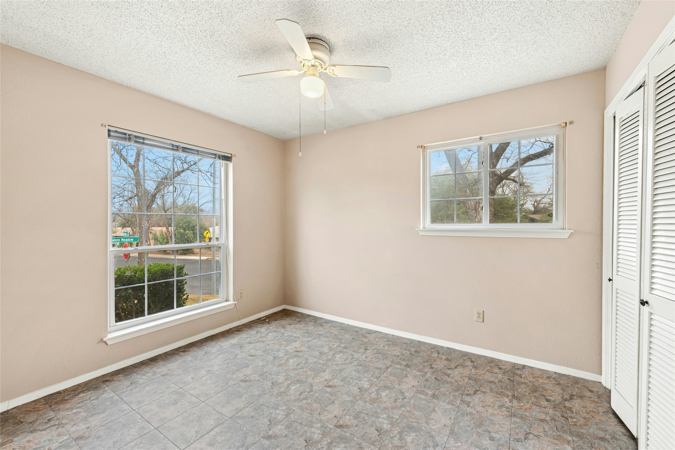 1444 Salem Meadow Circle Austin, TX 78745 - Photo 24 of 35 an empty room with windows and ceiling fan