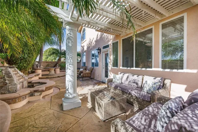 a view of a patio with couches table and chairs and potted plants