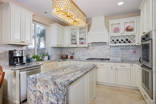 a kitchen with stainless steel appliances granite countertop a dining table chairs and a refrigerator