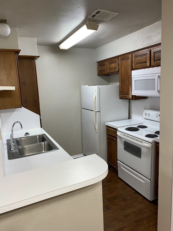 1305 West Villa Maria Road, Unit B104 Bryan, TX 77801 - Photo 3 of 14 a kitchen with a sink a stove and a refrigerator