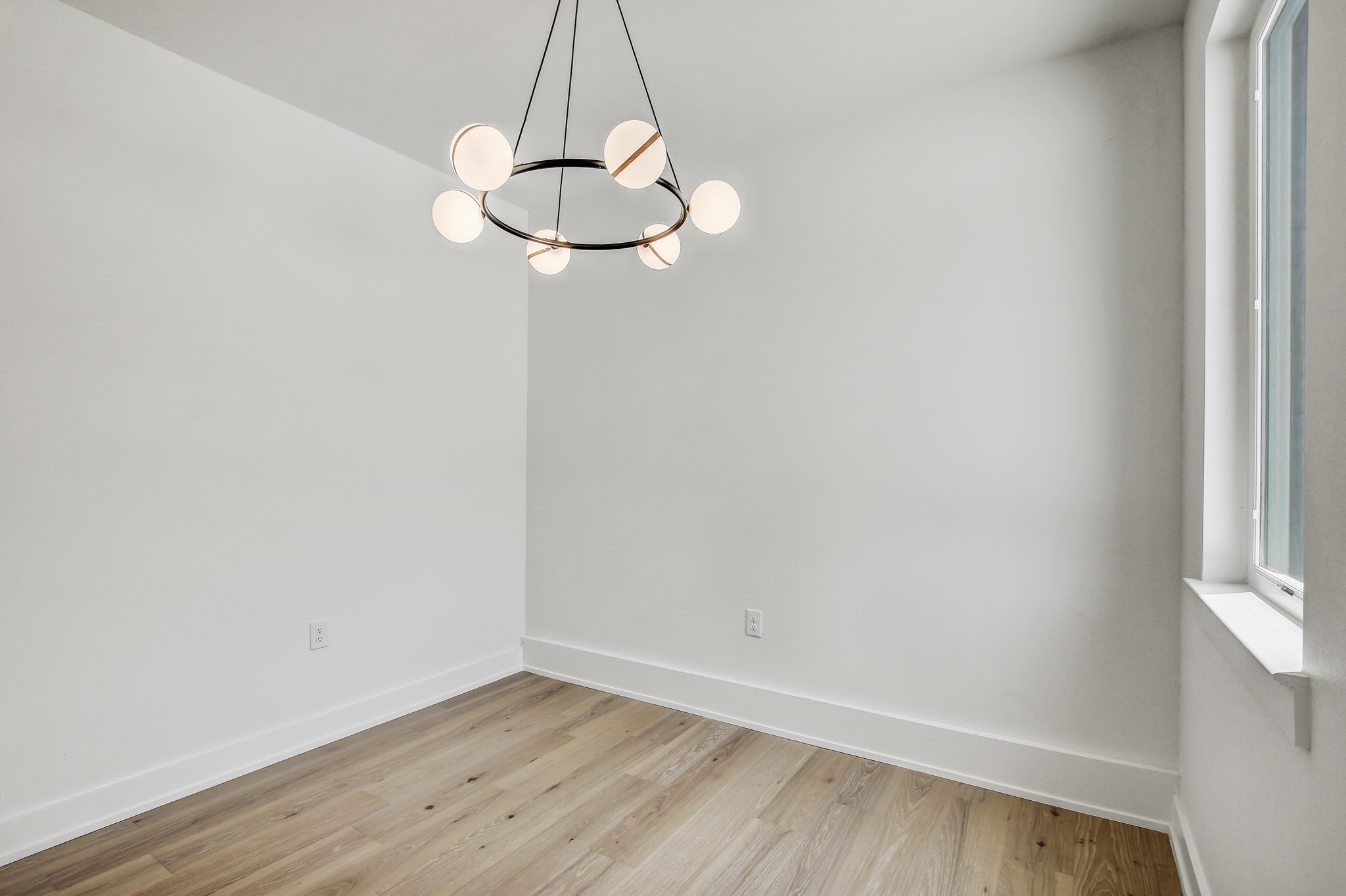 4127 East 12th Street, Unit 5 Austin, TX 78721 - Photo 17 of 33 Unfurnished room featuring light wood-type flooring, baseboards, and a chandelier