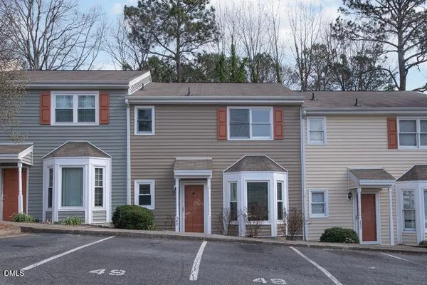a view of an empty room with wooden floor and a fireplace
