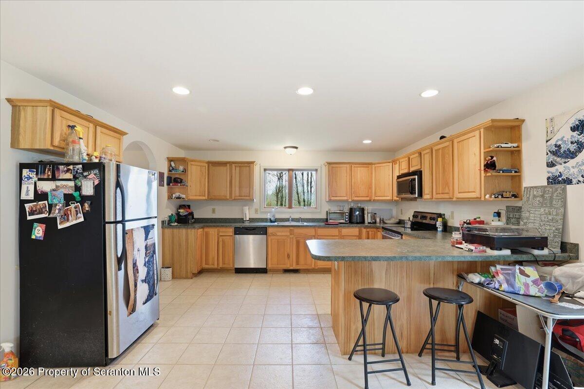381 Goose Pond Road Lake Ariel, PA 18436 - Photo 18 of 81 a kitchen with stainless steel appliances granite countertop a refrigerator a stove a sink a dining table and chairs
