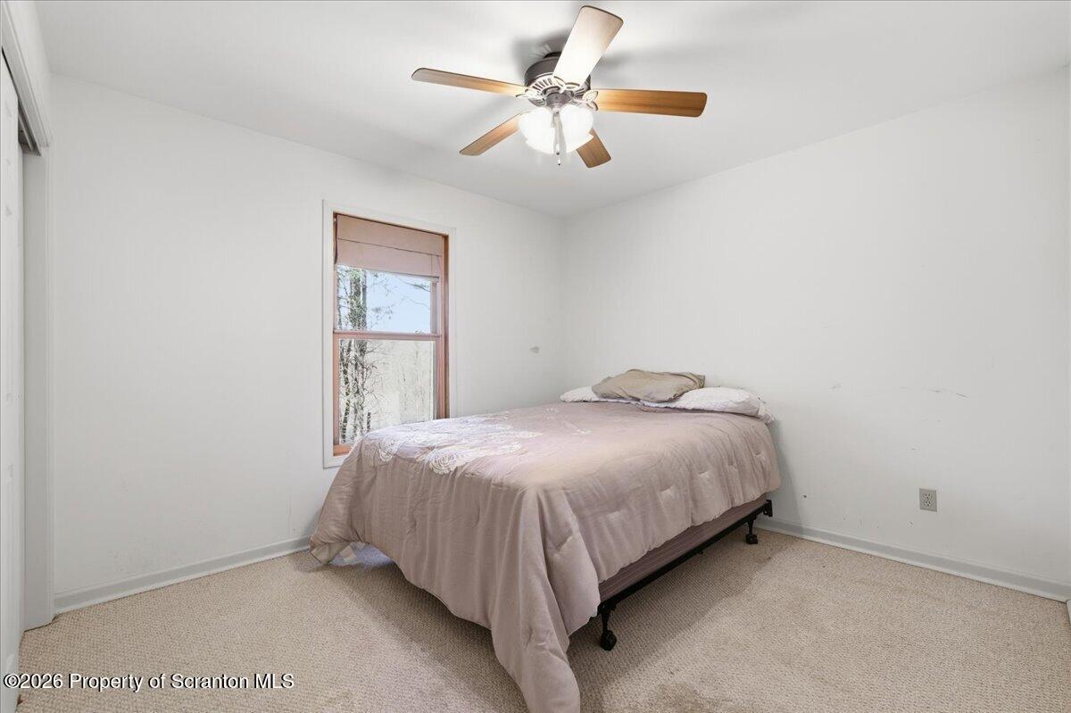 381 Goose Pond Road Lake Ariel, PA 18436 - Photo 29 of 81 a bed sitting in a bedroom next to a window and a chandelier
