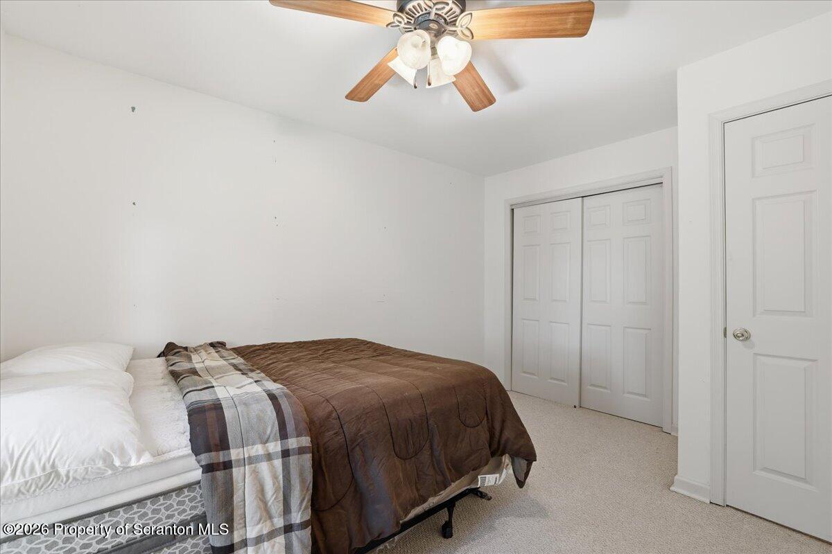 381 Goose Pond Road Lake Ariel, PA 18436 - Photo 32 of 81 a bedroom with a bed and a chandelier