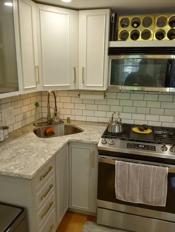 a kitchen with stainless steel appliances granite countertop a sink stove and microwave