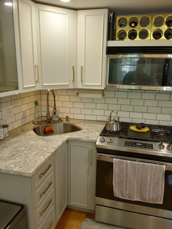 290 Columbus Avenue, Unit 4 Boston, MA 02116 - Photo 3 of 11 a kitchen with stainless steel appliances granite countertop a sink stove and microwave