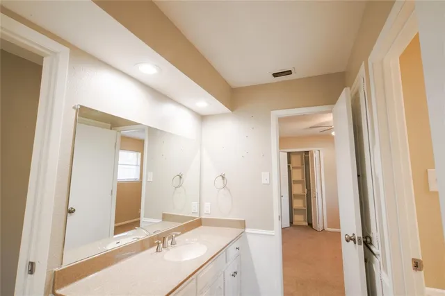 a spacious bathroom with a granite countertop sink and a mirror