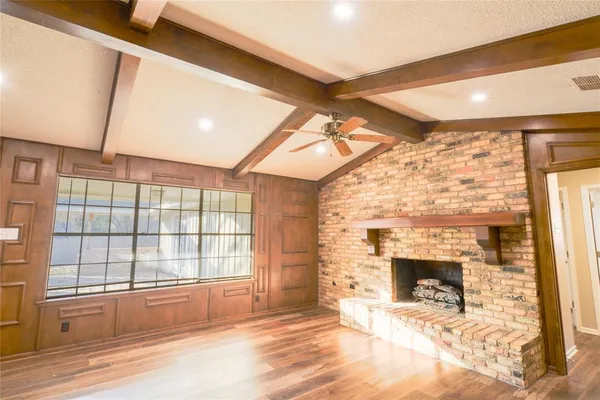 a view of an empty room with a fireplace and a window